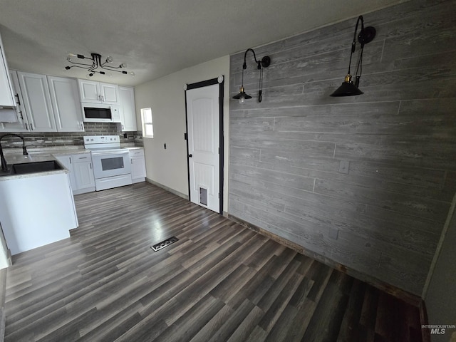 kitchen featuring white appliances, white cabinets, and a sink