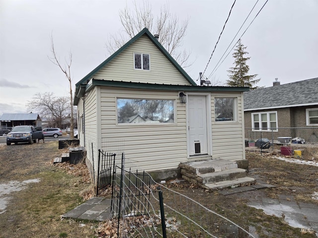 rear view of property with driveway and fence