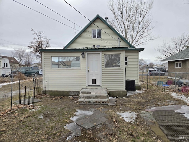 back of house featuring entry steps, central AC, and fence