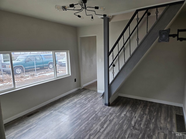 interior space featuring stairs, visible vents, baseboards, and wood finished floors