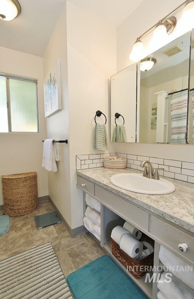 bathroom featuring vanity and tasteful backsplash