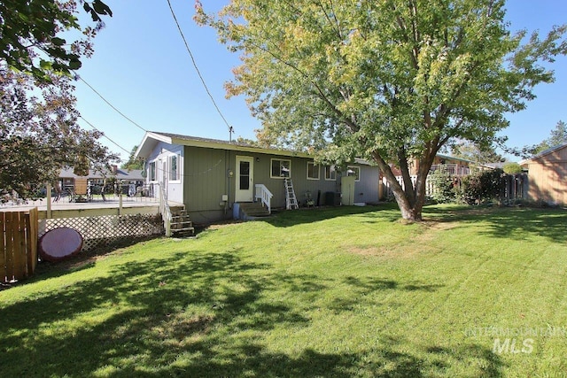 back of property with a wooden deck and a yard