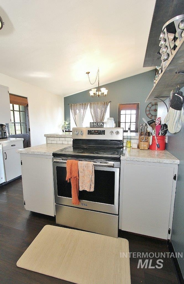 kitchen featuring white cabinetry, dark wood-type flooring, stainless steel range with electric stovetop, lofted ceiling, and a notable chandelier