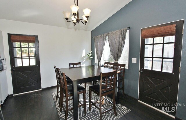 dining room with vaulted ceiling, dark hardwood / wood-style flooring, and a notable chandelier