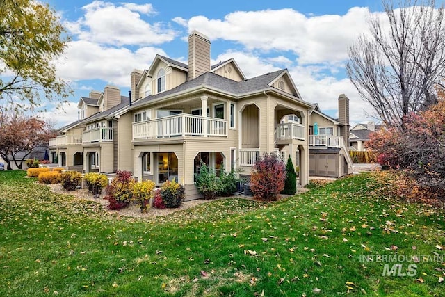 back of property with a balcony and a lawn