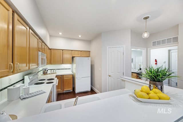 kitchen with pendant lighting, dark hardwood / wood-style flooring, and white appliances