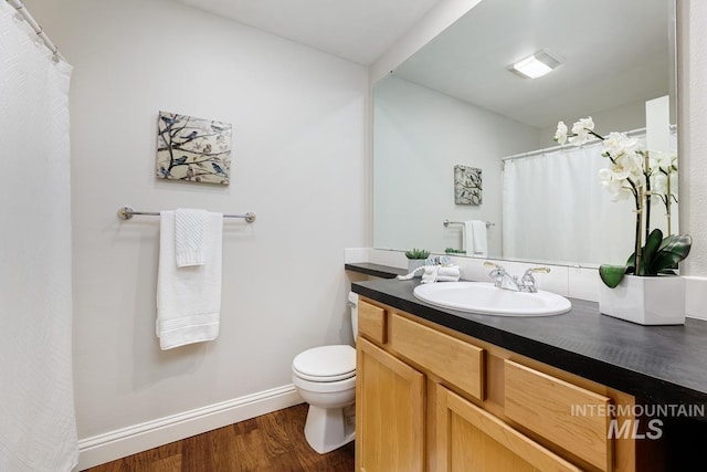 bathroom featuring toilet, vanity, and hardwood / wood-style flooring