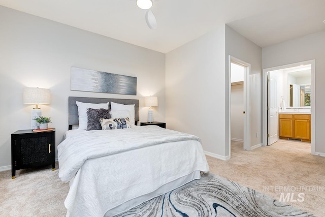 bedroom featuring ensuite bathroom, ceiling fan, and light carpet