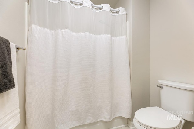 bathroom with shower / bath combination with curtain and toilet