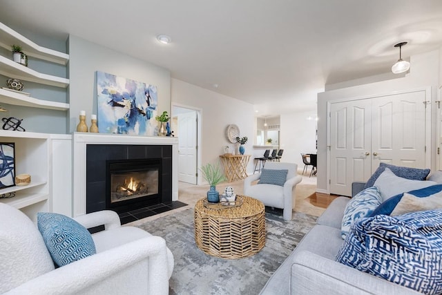 living room with hardwood / wood-style flooring and a tiled fireplace