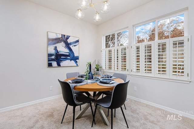 carpeted dining room featuring plenty of natural light and a chandelier