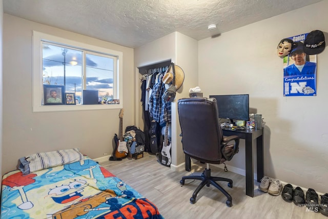 bedroom featuring hardwood / wood-style floors and a textured ceiling