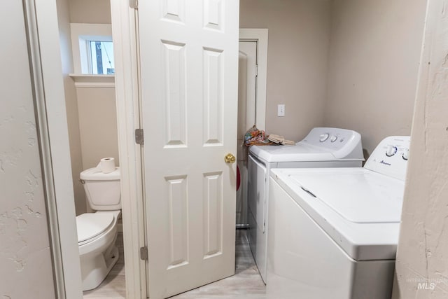 laundry area with light hardwood / wood-style floors and independent washer and dryer