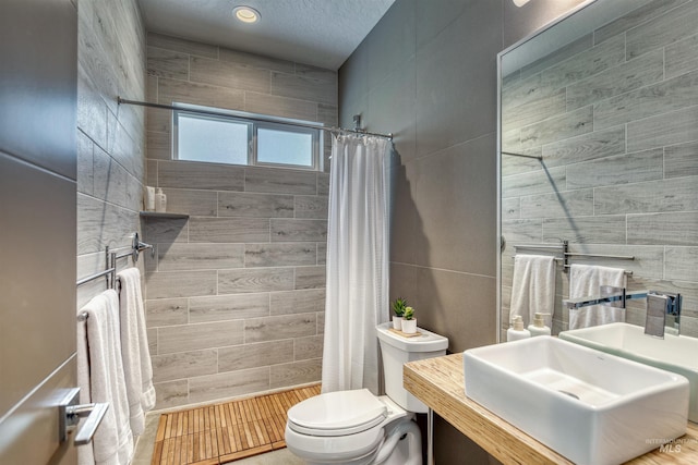 3600 N Prospect Way, Garden City, ID 83714 - full bath featuring tiled shower, toilet, tile walls, and vanity