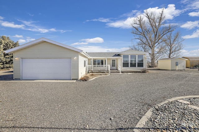 ranch-style house featuring a garage and a storage shed