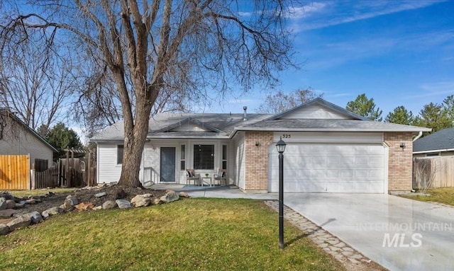 ranch-style house featuring a front lawn, brick siding, an attached garage, and fence