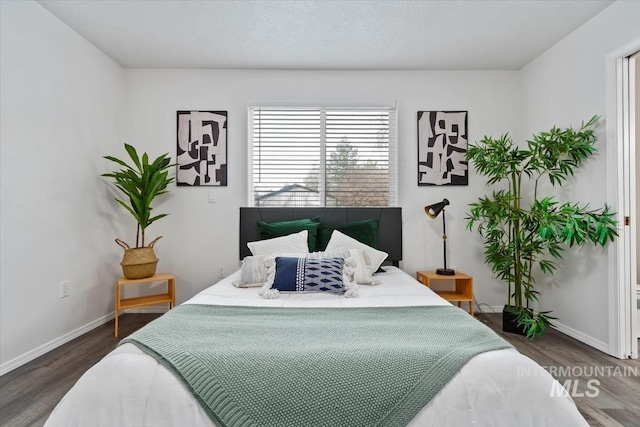 bedroom with baseboards and wood finished floors