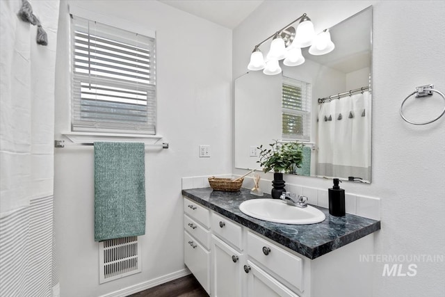 bathroom with visible vents, vanity, and baseboards