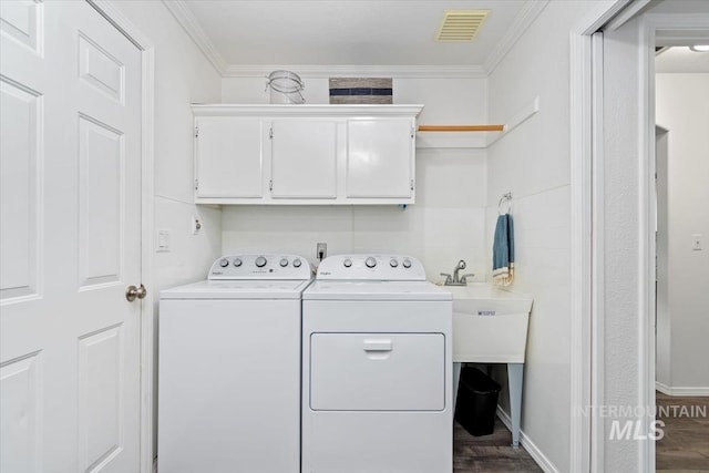 laundry room with visible vents, cabinet space, ornamental molding, and washer and clothes dryer