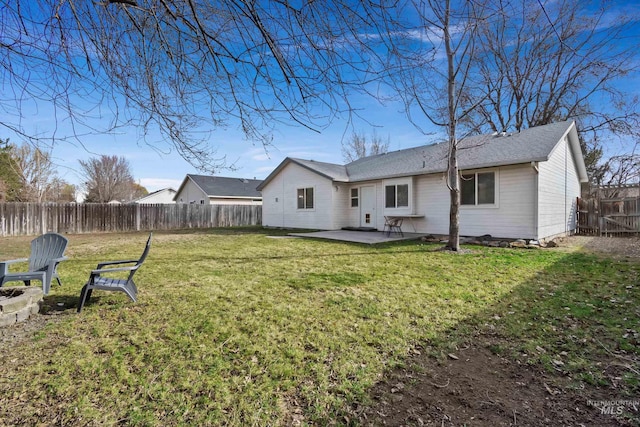 back of house with a fenced backyard, a lawn, a fire pit, and a patio