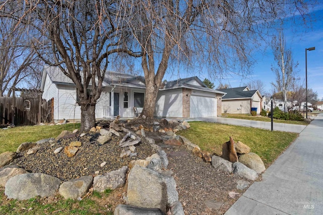 ranch-style home featuring driveway, fence, a front yard, an attached garage, and brick siding