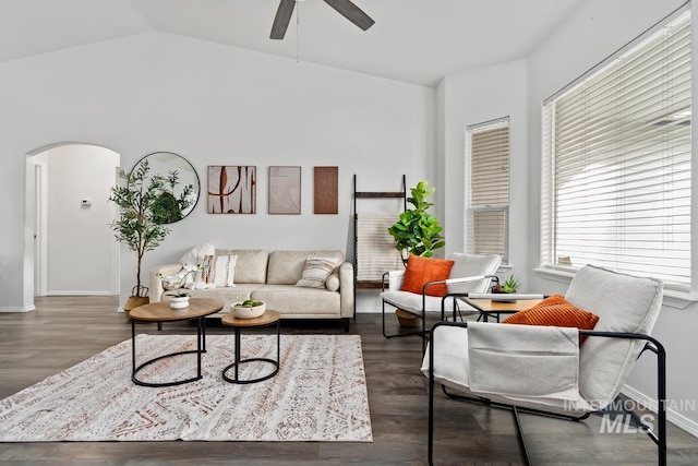 living area with wood finished floors, baseboards, arched walkways, ceiling fan, and vaulted ceiling