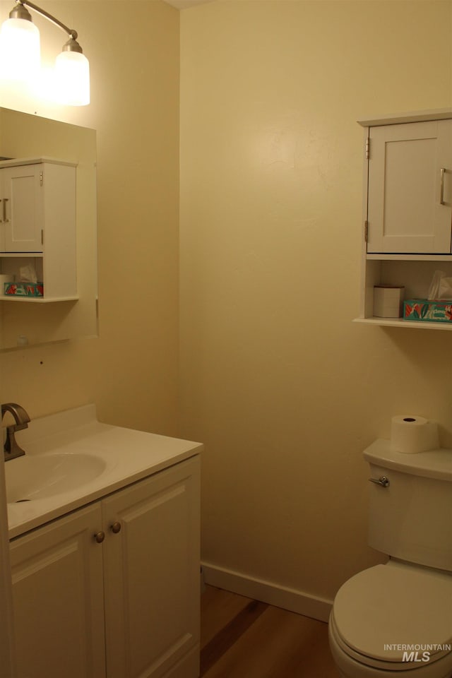 bathroom featuring toilet, hardwood / wood-style floors, and vanity