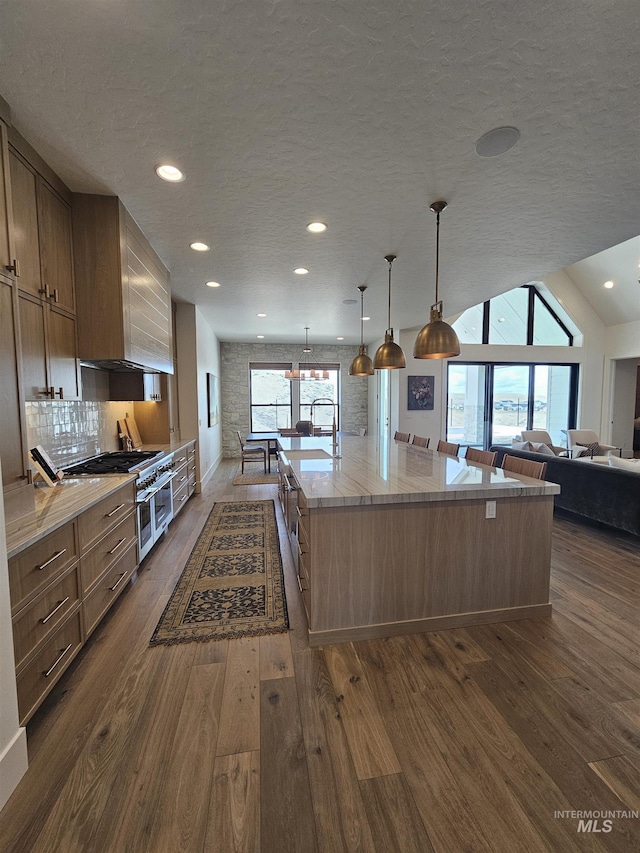 kitchen featuring a textured ceiling, decorative backsplash, dark wood finished floors, and recessed lighting