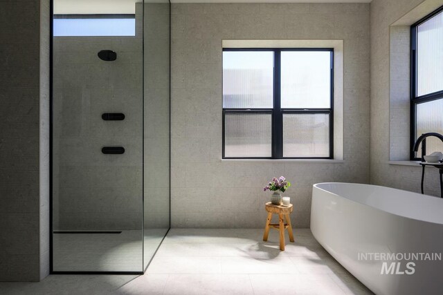 bathroom with walk in shower and a freestanding bath