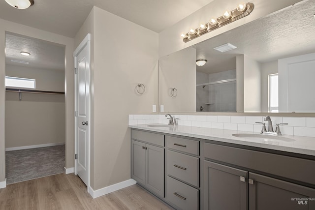 bathroom with hardwood / wood-style flooring, vanity, an enclosed shower, and a textured ceiling