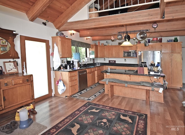 kitchen featuring appliances with stainless steel finishes, sink, pendant lighting, beamed ceiling, and dark hardwood / wood-style floors