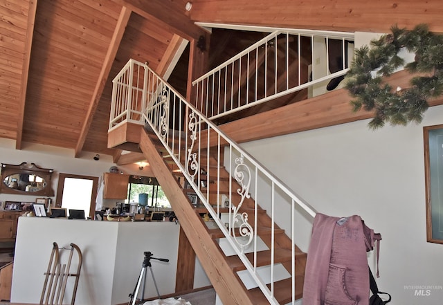 stairway featuring beamed ceiling, wooden ceiling, and high vaulted ceiling