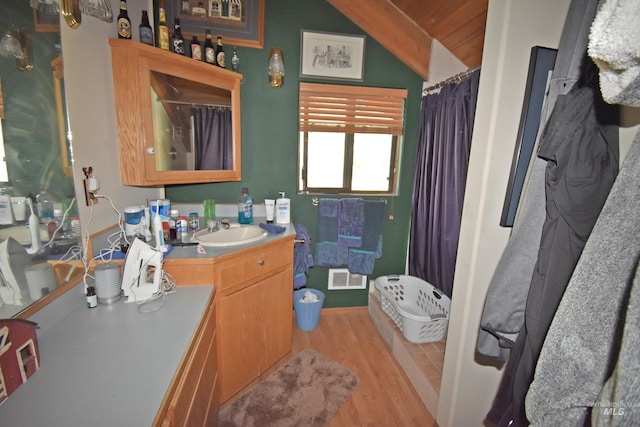 bathroom with hardwood / wood-style flooring, vanity, curtained shower, and lofted ceiling