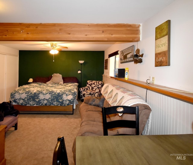 bedroom featuring carpet flooring, beam ceiling, and ceiling fan