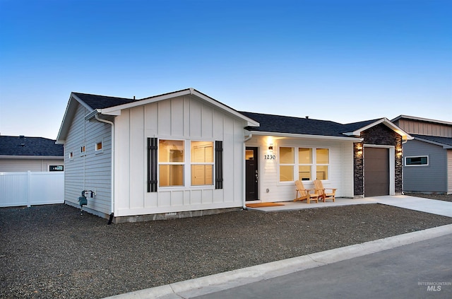 view of front of house featuring concrete driveway, board and batten siding, crawl space, fence, and a garage