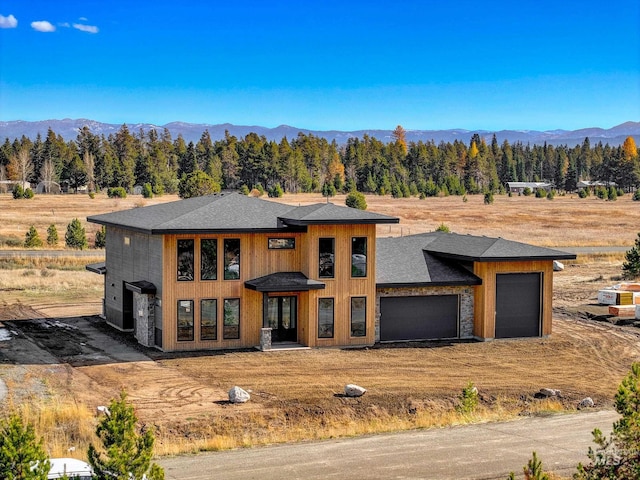 13156 Hawks Bay, Donnelly, ID 83615 - prairie-style house featuring a garage, driveway, a mountain view, a shingled roof, and a forest view