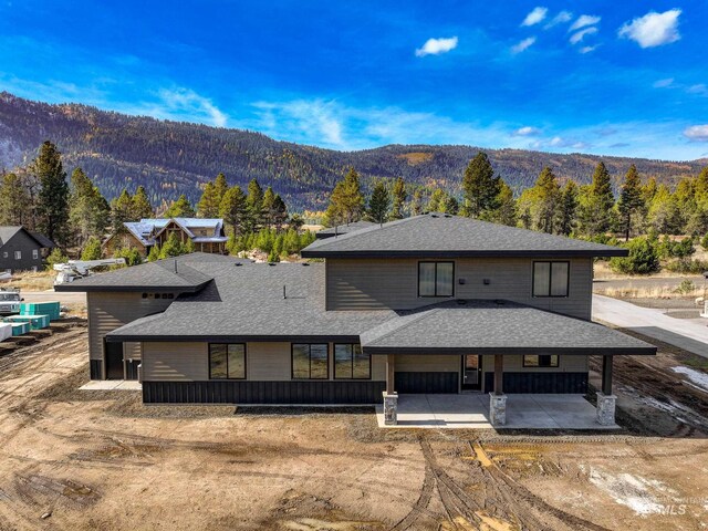 13156 Hawks Bay, Donnelly, ID 83615 - back of property featuring a mountain view, a patio area, and roof with shingles