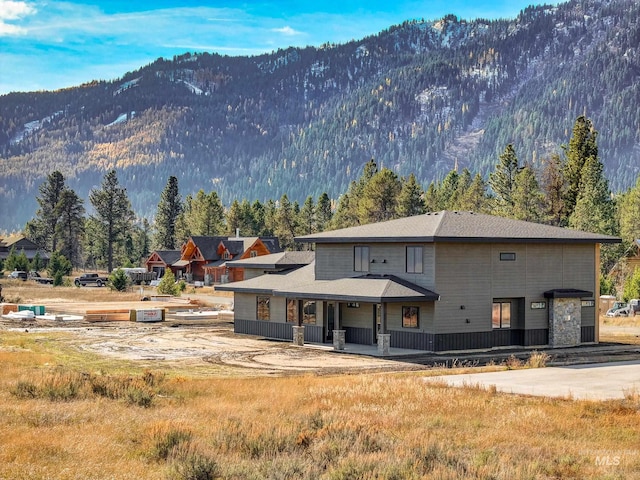 13156 Hawks Bay, Donnelly, ID 83615 - rear view of house featuring a mountain view, covered porch, and a wooded view