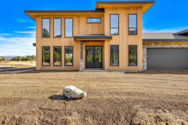 13156 Hawks Bay, Donnelly, ID 83615 - modern home featuring french doors, an attached garage, and a mountain view