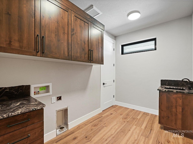 13156 Hawks Bay, Donnelly, ID 83615 - laundry area featuring cabinet space, washer hookup, light wood-style flooring, and baseboards