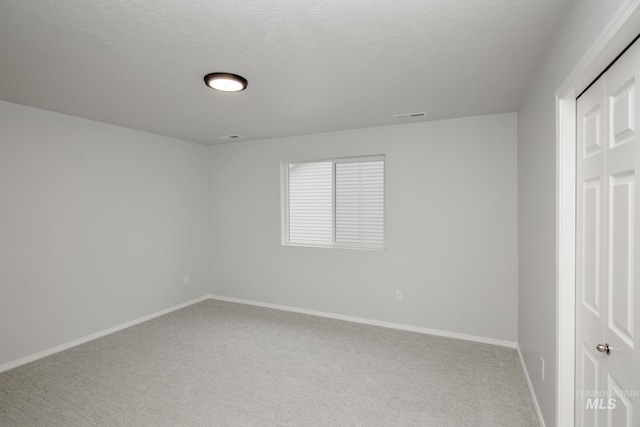 interior space featuring a closet, carpet flooring, and a textured ceiling