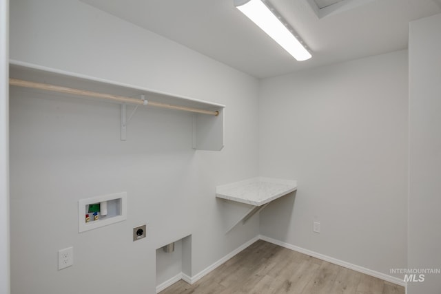 clothes washing area with hookup for a washing machine, hookup for an electric dryer, and light hardwood / wood-style floors