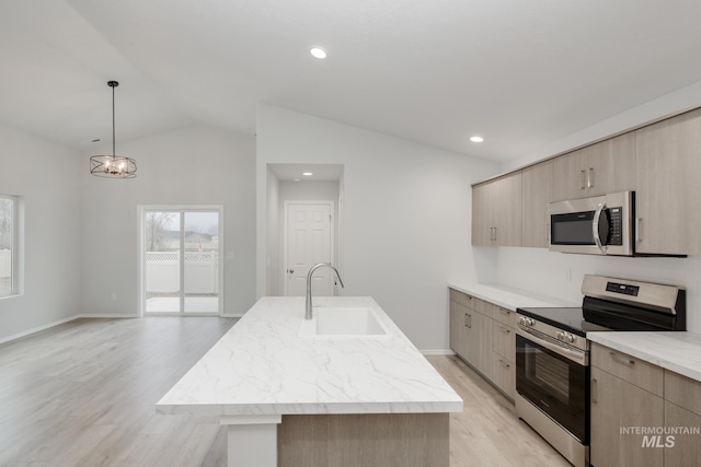 kitchen featuring appliances with stainless steel finishes, hanging light fixtures, a kitchen island with sink, sink, and vaulted ceiling