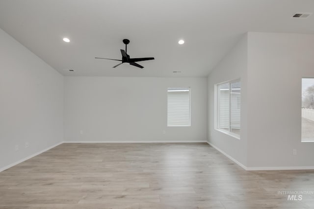 spare room featuring light wood-type flooring, ceiling fan, and vaulted ceiling