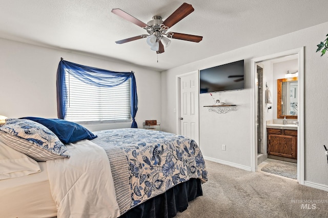 bedroom featuring a textured ceiling, connected bathroom, ceiling fan, carpet, and baseboards