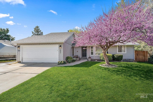 view of front facade with a garage, driveway, a front lawn, and fence
