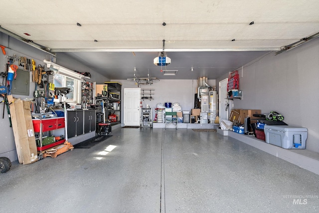 garage featuring water heater, a garage door opener, and electric panel