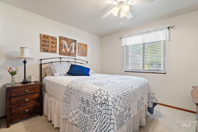 bedroom with baseboards, a ceiling fan, and light carpet