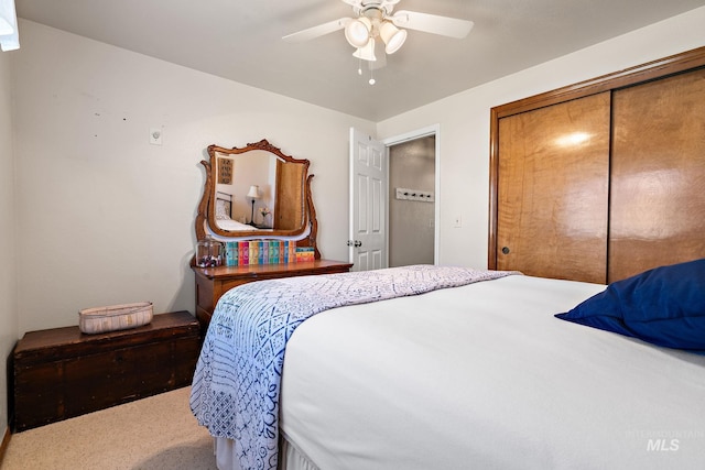 carpeted bedroom with ceiling fan and a closet