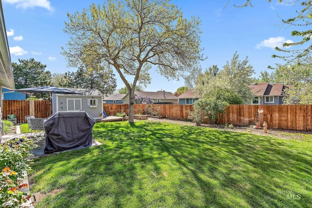 view of yard with a fenced backyard, an outdoor structure, and a residential view
